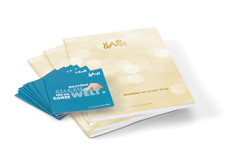 Auf dem Bild sind ein Produktkatalog und mehrere Karten zu sehen, die sich auf biokäse und eine Verbindung zur Region Allgäu beziehen.